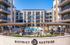 Luxury apartment community featuring modern architecture and a stunning central pool area, perfect for relaxation and social gatherings.