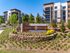 Modern apartment complex of District Eastside surrounded by lush landscaping, featuring contemporary architecture with balconies.