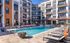 Modern apartment complex with inviting outdoor pool area, stylish poolside loungers, and contemporary architecture.