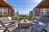 Luxurious outdoor seating area with modern fire pit and stunning apartment views.