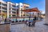 Modern apartment complex with poolside view, featuring a stylish outdoor seating area and spacious balconies.