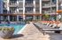Luxurious apartment complex with a refreshing pool, modern loungers, and elegant balconies for a perfect retreat.