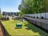 Beautiful apartment view featuring a fenced dog park with play structures, surrounded by lush greenery and modern apartment buildings in the background.