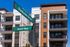 Modern apartment building at the corner of Eastside Drive and Avertt Way, featuring spacious balconies and stylish architecture against a clear blue sky.