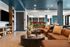 Contemporary lounge area with stylish brown couches, modern decor, and an inviting open-concept seating arrangement.