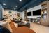 Contemporary living room with elegant brown sofas, artistic wall decor, and stylish bookshelves in a cozy apartment setting.