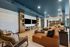 Modern open-concept living room with cozy seating, stylish decor, and a sleek entertainment center, leading into a spacious dining area.