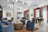 Modern communal lounge area with stylish seating and contemporary decor, featuring large windows for natural light.