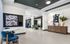 Modern community lounge area featuring a large Scrabble board, contemporary seating, and elegant decor, perfect for socializing or relaxing.