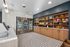 Chic and modern apartment lobby with a stylish snack station featuring refrigerated drinks and a variety of snacks on elegant wooden shelves.