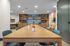 Contemporary creative studio with a large wooden table, vibrant supplies, and art easels, perfect for inspired gatherings.