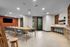 Elegant and modern community room with a spacious wooden table, trendy chairs, and a vibrant accent wall, perfect for gatherings or meetings.
