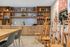 Bright and modern art room featuring wooden easels, organized shelving with colorful art supplies, and a sleek countertop with a stylish backsplash.