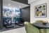 Modern apartment corner with stylish fitness area featuring treadmills and artistic ambiance, adjacent to an elegant dining space with green velvet chairs.