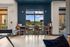 Chic apartment lounge with pool view, stylish seating, and modern decor against a vibrant color palette.