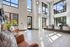 Spacious and bright lobby with modern decor, high ceilings, and abundant natural light through large windows.