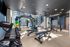 Modern gym with state-of-the-art equipment, including free weights and cardio stations, in a bright, spacious setting.