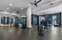 Modern and spacious gym featuring state-of-the-art equipment, sleek flooring, and abundant natural light.