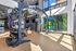 Modern fitness center with a spacious interior, featuring high-end weight racks, colorful plates, and a professional punching bag, bathed in natural light.