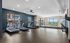 Modern fitness center with multiple treadmills, large windows, and a view of the cityscape in a luxurious apartment complex.