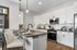 Modern kitchen with sleek white cabinetry, stainless steel appliances, and a chic island breakfast bar with pendant lighting.