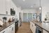 Modern kitchen with sleek white cabinets, stainless steel appliances, and elegant countertops in a spacious open layout.
