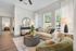 Bright, modern living room with beige sofa, stylish decor, and large windows offering abundant natural light.
