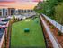 Inviting apartment complex with a lush green dog park, modern buildings, and vibrant sunset backdrop, offering a perfect living environment.