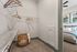 Spacious walk-in closet with ample shelving, stylish wooden hangers, and a cozy view into the modern bedroom.