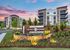 Charming District Eastside apartment complex surrounded by lush landscaping, showcasing modern architecture against a vibrant sunset sky.