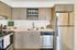 Modern kitchen with sleek stainless steel appliances, elegant wood cabinetry, and a stylish countertop, perfect for culinary enthusiasts.