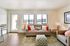 Bright living room with modern sofa, colorful cushions, and large windows offering stunning views, perfect for relaxation.
