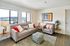Bright and inviting living room with stylish decor, large windows offering a scenic view, and comfortable seating.