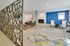 Chic living room with modern geometric screen, vibrant blue accent wall, cozy fireplace, and stylish seating arrangement on a colorful patterned rug.