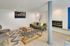 Chic modern living room with a sleek fireplace, cozy seating, and stylish decor in an inviting open layout.