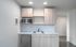 Modern kitchen with sleek cabinetry, a stainless steel sink, and a convenient built-in microwave, offering a stylish and functional space.