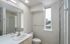 Bright and modern bathroom with sleek fixtures, spacious shower, and large window offering natural light.