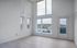 Bright and airy room with floor-to-ceiling windows and scenic urban view.