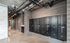 Modern apartment hallway featuring sleek mailboxes set against stylish wood-panel walls and exposed industrial piping.