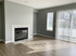 Bright living room with modern fireplace, elegant flooring, and large windows with vertical blinds for ample natural light.