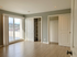 Bright and spacious bedroom featuring sliding glass door access to a balcony, sleek wood floors, built-in closet, and panoramic city views.