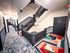 Chic apartment corridor with modern staircase, vibrant geometric carpet, and sleek black doors.