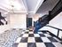 Chic apartment lobby featuring modern geometric flooring, elegant staircase, and artistic wall decor for a stylish welcome.