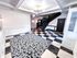 Chic apartment lobby with modern checkered flooring, elegant staircase, and contemporary lighting.