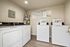 Modern laundry room equipped with efficient washers and dryers, surrounded by informative signage and bright lighting.