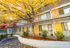 Charming apartment complex with vibrant yellow doors and lush autumn foliage offering a welcoming atmosphere.