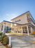 Modern apartment building 'Monticello' with elegant architecture, featuring large windows and inviting entrance nestled in a picturesque setting.