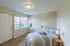 Inviting bedroom with natural light, plush carpet, and cozy double bed, perfect for relaxation and comfort.