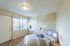 Cozy bedroom with large window, soft lighting, and elegant decor offering a peaceful retreat.