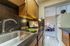 Modern kitchen with sleek countertops, elegant backsplash, and cozy dining area in view.